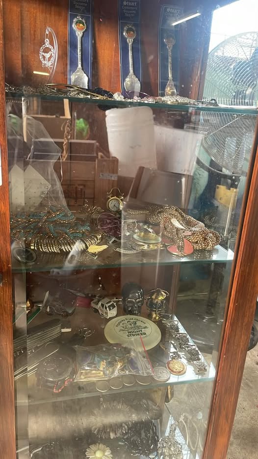 Glass cabinet of collector spoons, jewellery and watches