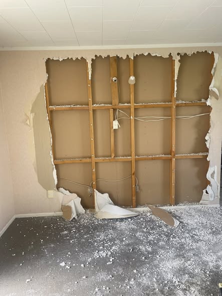 Mid-demolition inside a house — framing exposed and gib stripped, Junk Masters demo day in Otorohanga